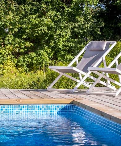 Vita solstolar vid poolkant Pool Store