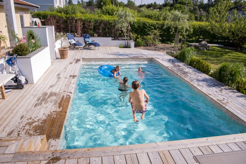 Poolmiljö på altan i trädgård.