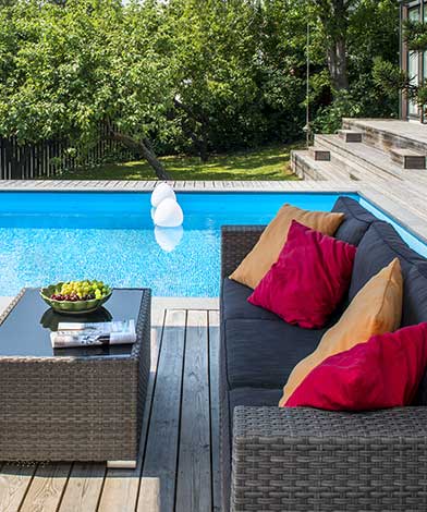 Pool med loungemöbler på trädäck.