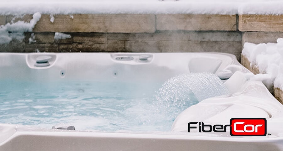 Öppet spabad med snö omkring med FiberCor logga